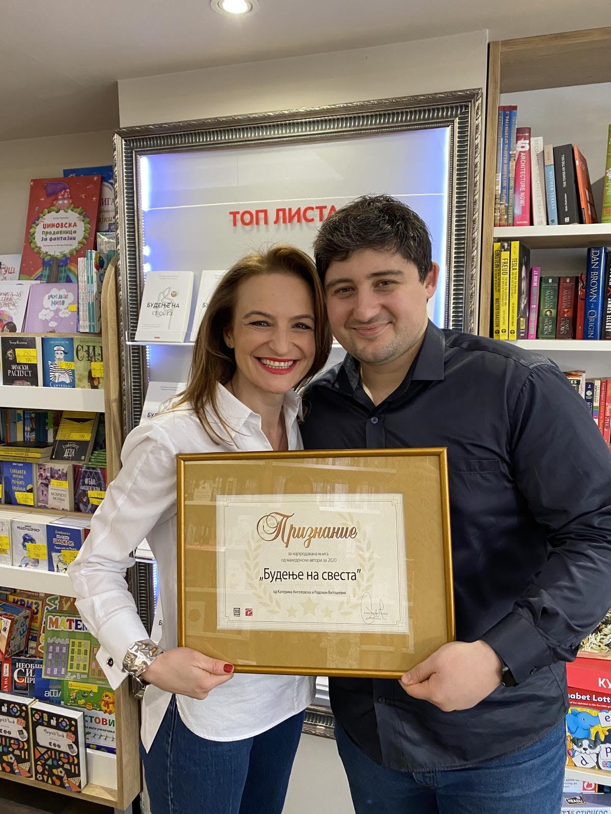 Katerina Angelovska and Radovan Vitosevic holding the award certificate at the Top List display in Knizarnica Tri